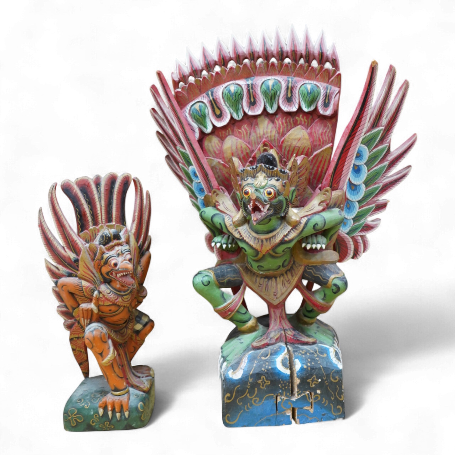 A Balinese painted and carved wood sculpture of Garuda, together with a smaller similar carving, largest 46cm high
